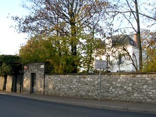 Une maison de caractère, dans un parc entouré de murs en pierre.